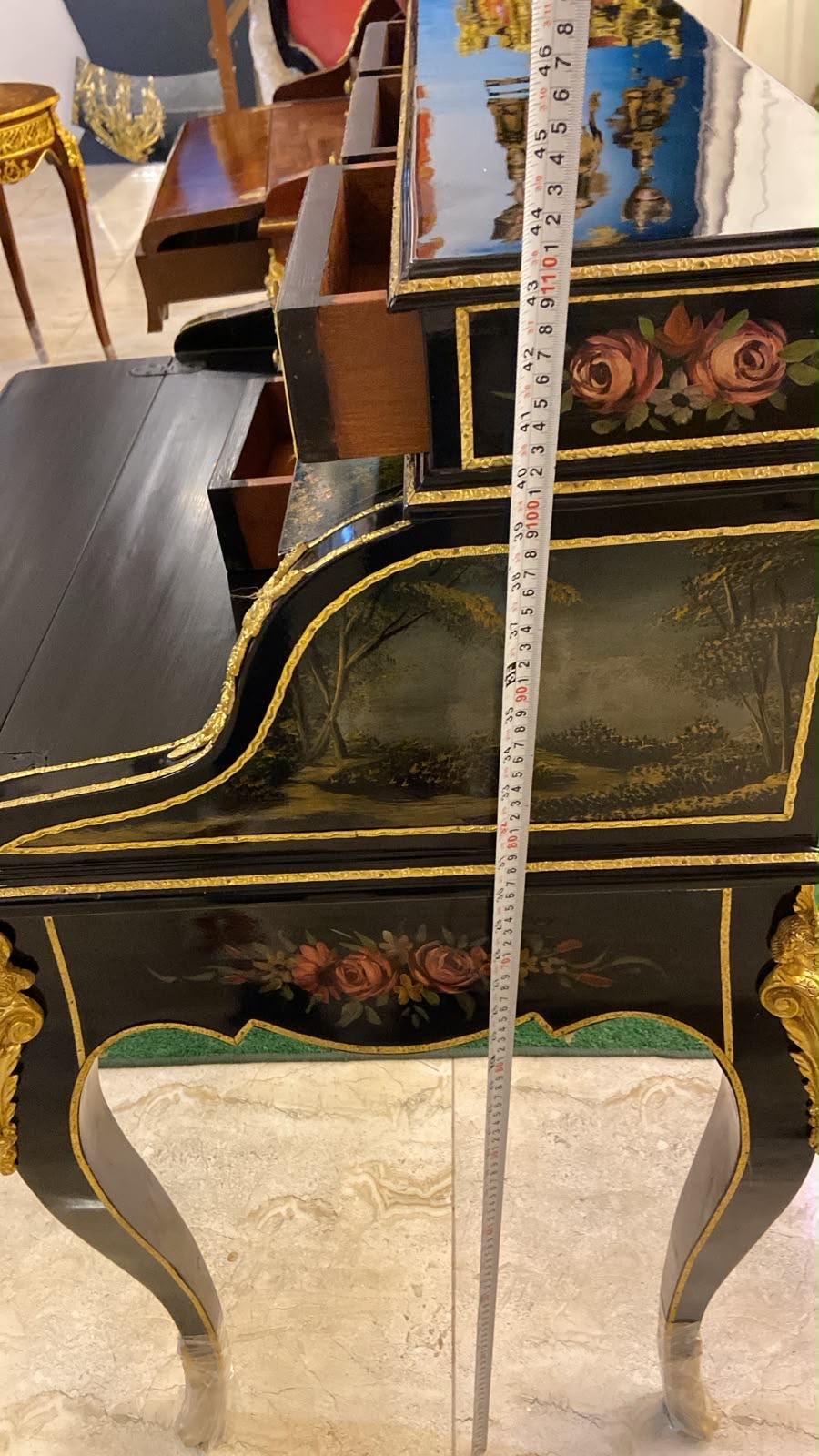 May include: A black lacquered secretary desk with hand-painted floral motifs and landscape scenes, featuring gold trim and ornate metal accents. A vertical measuring tape is placed against the side, showing a height of approximately 46 inches.
