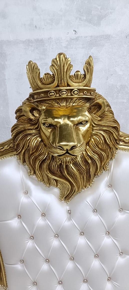 May include: A chair featuring a gold-colored lion head sculpture at the top, wearing a matching gold crown. The backrest is upholstered in white tufted material with embedded crystal-like buttons, creating a diamond pattern across the surface.