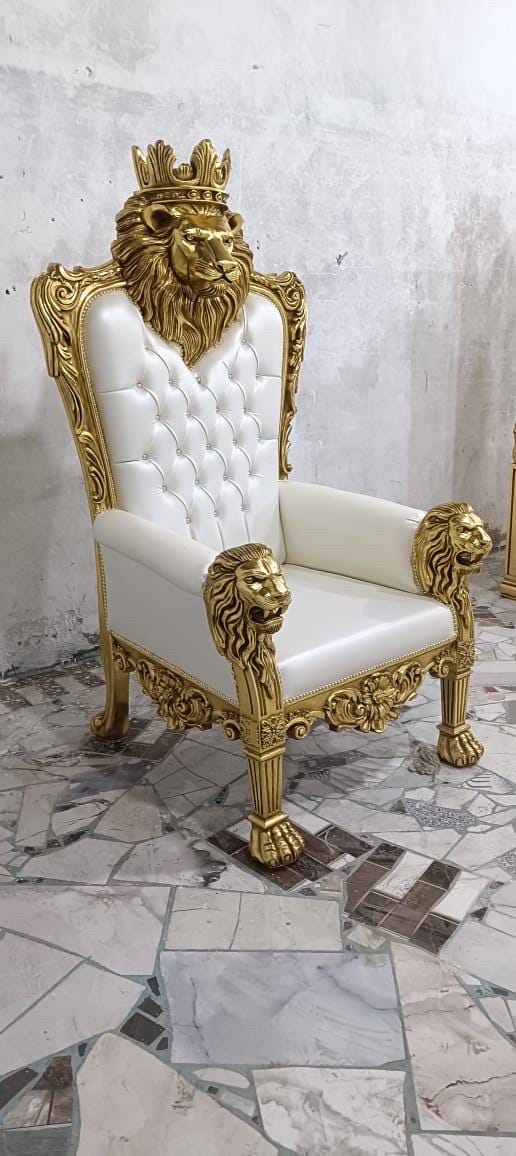 May include: A high-back throne chair featuring a white tufted upholstered seat and backrest. The frame is finished in gold and decorated with carved lion heads at the armrests and a large lion head with a crown at the top of the backrest.
