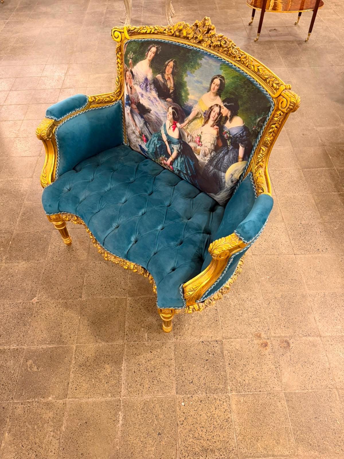 May include: A two-seat settee featuring a gold-painted wooden frame with ornate carved details. The seat is upholstered in tufted teal velvet. The backrest displays a printed fabric panel depicting a group of women in historical attire.