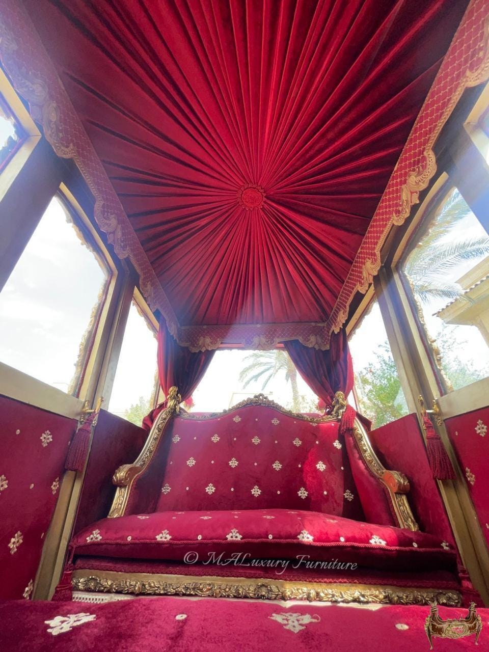 May include: A red velvet carriage interior featuring a tufted ceiling canopy with gold trim, a matching red velvet bench seat with gold embroidered accents, and gold-toned frame details. The text MALuxury Furniture is visible on the seat.