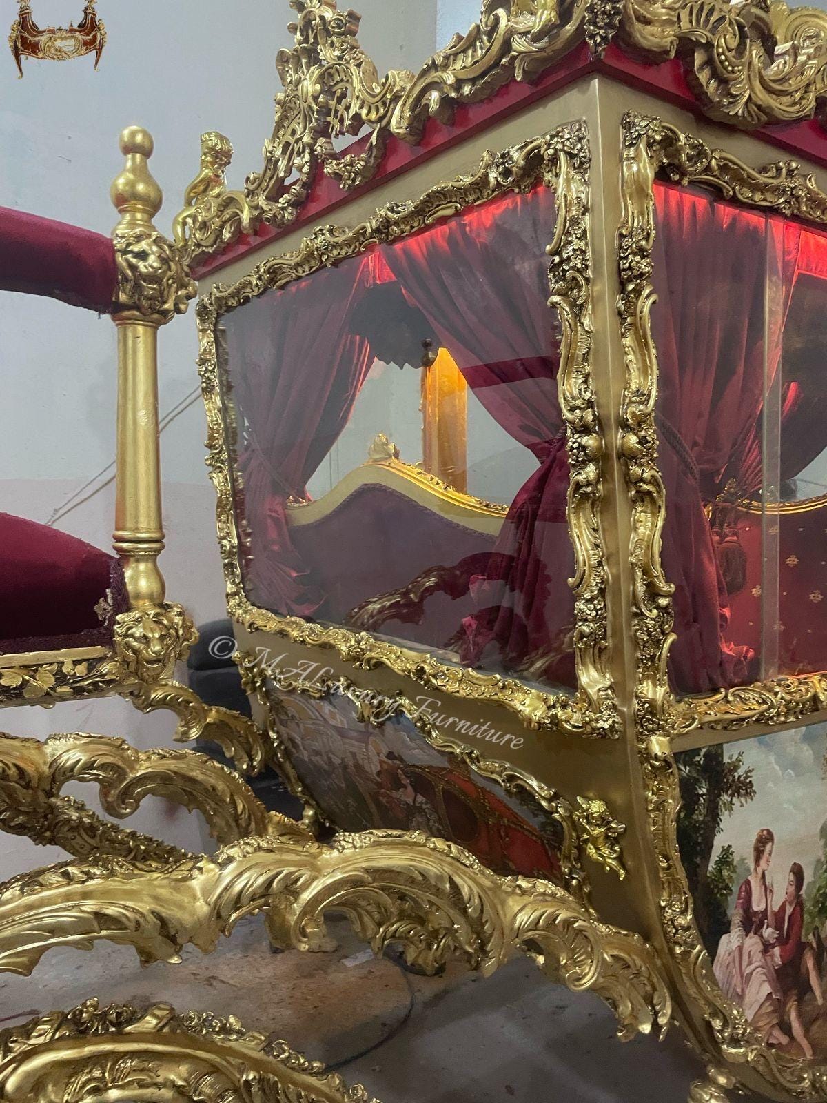 May include: A gold-finished carriage-style furniture piece featuring ornate carved details, deep red velvet upholstery, and transparent side panels. The exterior displays painted pastoral scenes, and the text "MAL Furniture" is visible on the side.