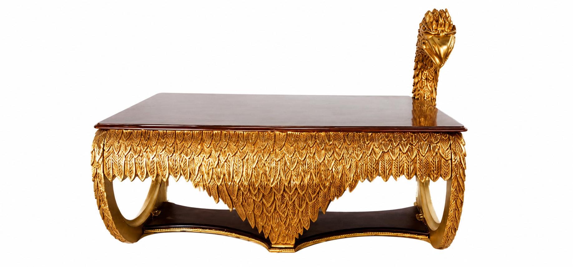 May include: A rectangular coffee table with a dark brown polished top and a gold-colored base featuring intricate carved feather details. The table includes a sculpted bird head extending upward from one corner of the frame.